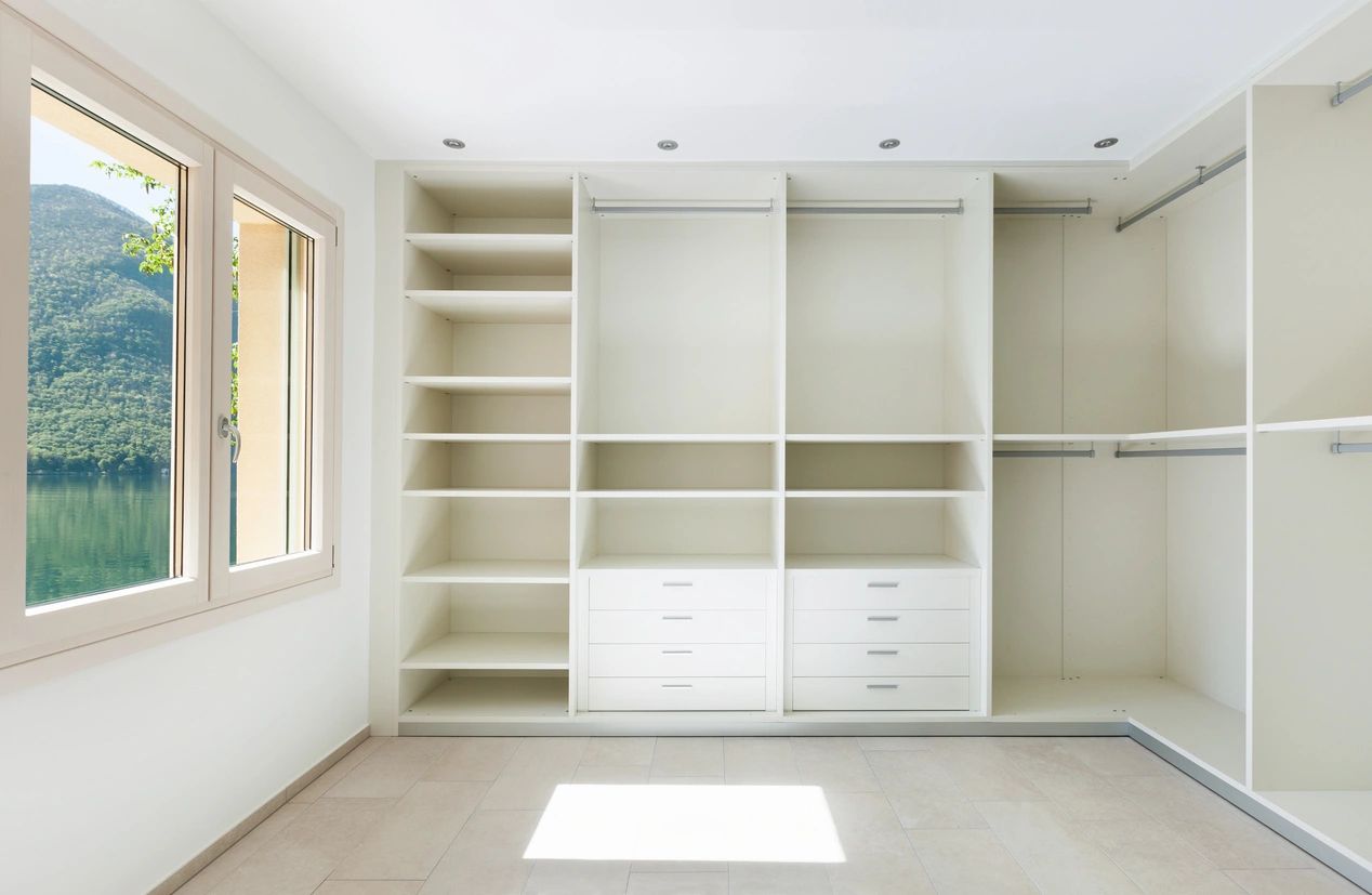 A white room with many shelves and drawers.