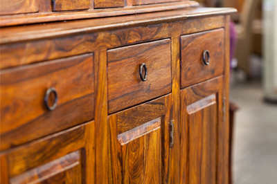 A close up of the drawers and doors on an old dresser.